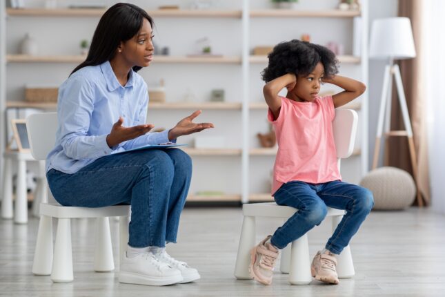 african,american,young,woman,psychotherapist,talking,to,unruly,little,girl