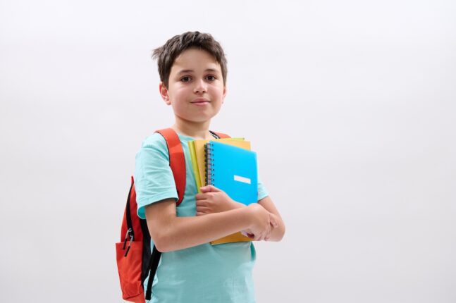 happy,positive,teenager,smiling,looking,at,camera.,smart,schoolboy,carrying